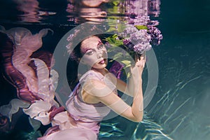 Woman in colorful clothes swimming underwater