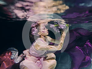 Woman in colorful clothes swimming underwater