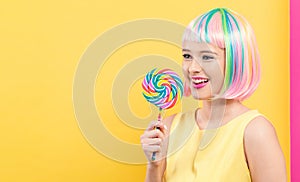 Woman in a colorful wig with a lollipop