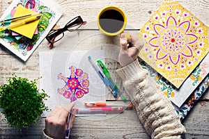 Woman coloring an adult coloring book, new stress relieving trend, mindfulness concept