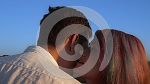 Woman with coloured hair whispers to man`s ear