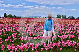 Woman in colourful fields of tulips.