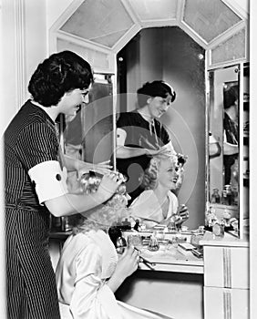 Woman combing another womans hair