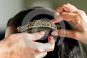 woman combing hair with a decorative comb