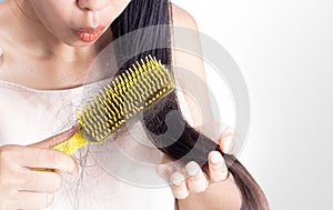 A woman is combing hair and hair loss