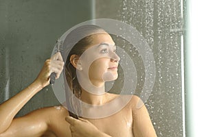 Woman combing hair while showering