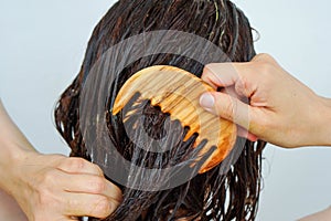 Woman combing hair treatment through hair