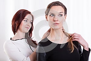 Woman combing hairs her friend