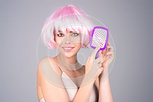 Woman combing her hair. Cares about a healthy and clean hair. Beauty hair salon concept. Girl with a comb in studio