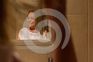 Woman combing her hair in the mirror