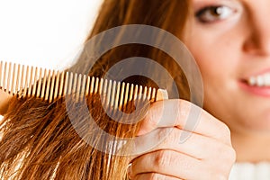 Woman combing and pulls hair.