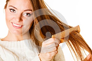 Woman combing and pulls hair.