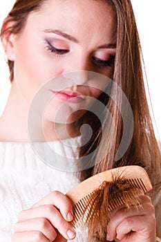 Woman combing and pulls hair.