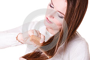 Woman combing and pulls hair.