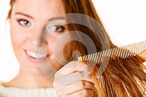 Woman combing and pulls hair.