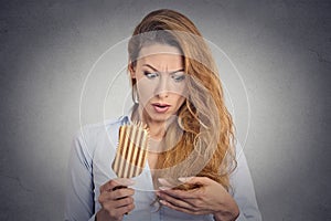 Woman combing surprised she is losing hair, receding hairline