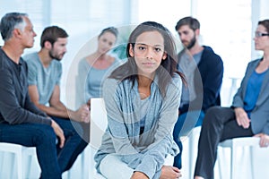 Woman comforting another in rehab group at therapy