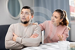 Woman comforting offended husband after spat at home
