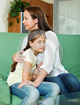 Woman comforting sad little daughter