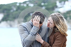 Woman comforting a sad man in winter