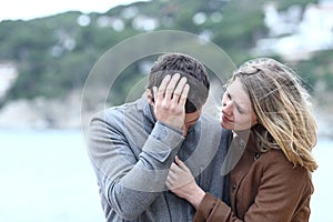 Woman comforting a sad man in winter photo