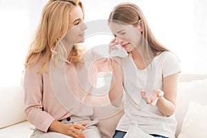 A woman comforts a teenage daughter.