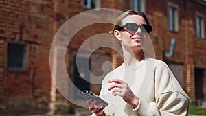 Woman in comfy outfit looking at smartphone screen while walking in city