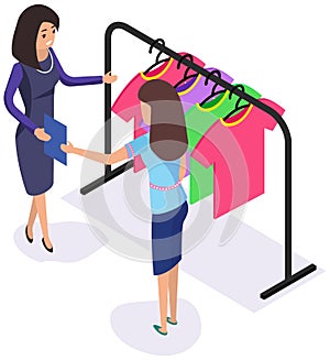 Woman communicating with consultant in shop while shopping. Clothes on hanger for sale in store