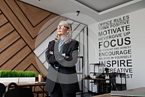 woman company owner businesswoman stands in the middle of the office and looks thoughtfully out the window