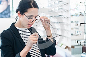 Woman comparing glasses at optician