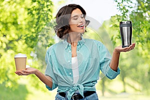 Woman comparing thermo cup and paper coffee cup