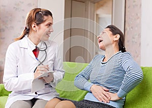 Woman complaining to doctor about stitch in side