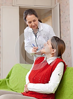 Woman complaining to doctor about stomachache