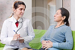 Woman complaining to doctor about tummy-ache