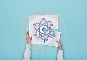 Woman completing a puzzle with atom icon