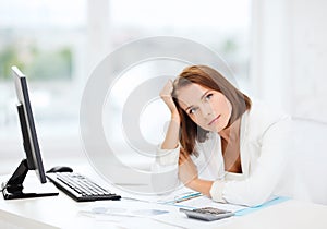 Woman with computer, papers and calculator