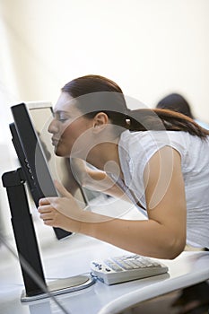 Woman in computer room kissing monitor