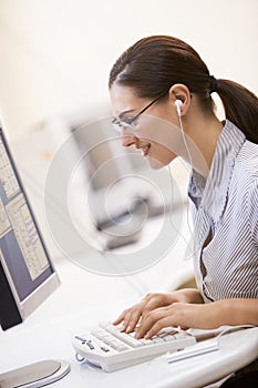 Woman in computer room listening to MP3 Player