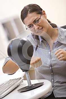 Woman in computer room using small punching bag