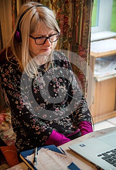 Woman at computer,watching webinar on her laptop,wearing headphones photo