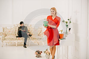 Woman concept. Happy woman smile with spring flower while man reading book. Sensual woman hold potted flower. Woman