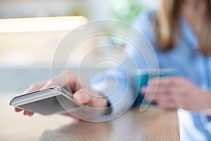 Woman Concerned About Excessive Use Of  Social Media Laying Mobile Phone Down On Table photo