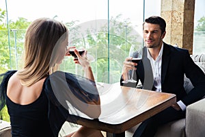 Woman and confident man drinking red wine