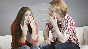 Woman confiding to man on sofa