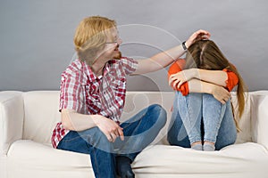 Woman confiding to man on sofa