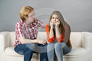 Woman confiding to man on sofa