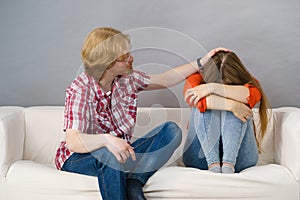 Woman confiding to man on sofa