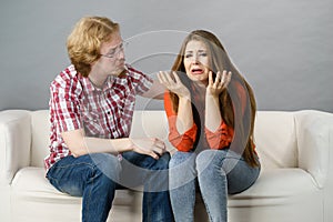 Woman confiding to man on sofa