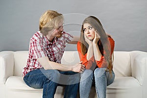 Woman confiding to man on sofa