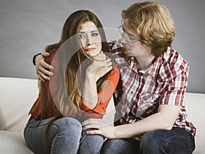 Woman confiding to man on sofa